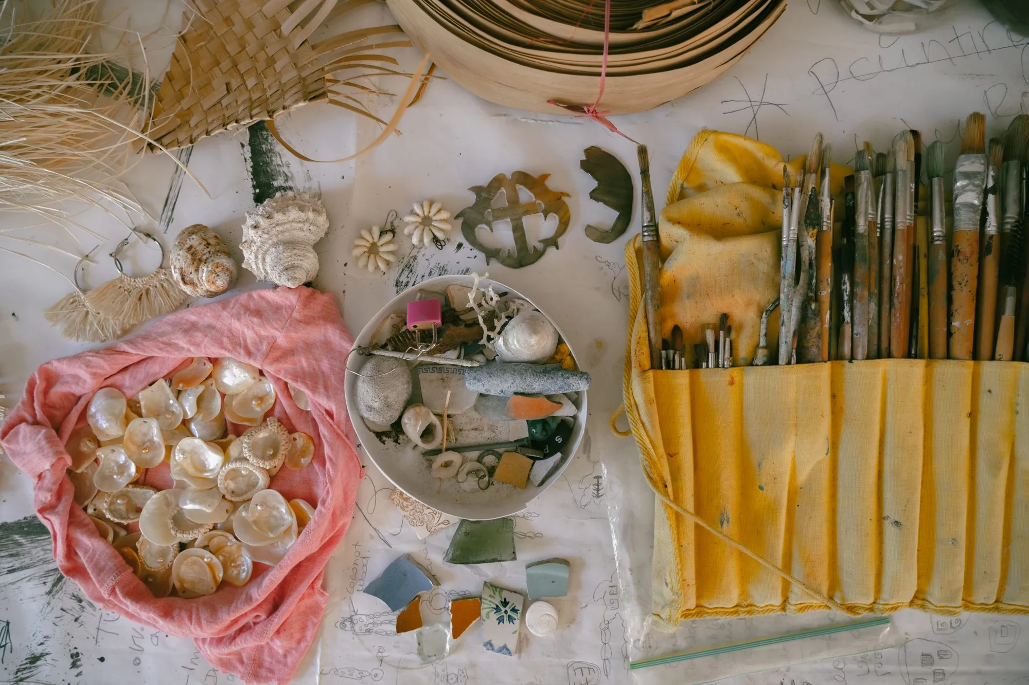 Table d'atelier : nacre, coquillages, pinceaux et vannerie